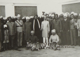 Colonel H.H. The Maharaja Sawai Sir Tej Singh Prabhakar of Alwar is seen with a man-eating tiger he shot down.