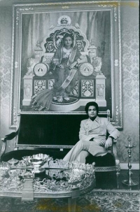 Prince Sayajirao Gaekwar sitting in front of a life-size portrait of his mother Sita Devi, Maharani of Baroda